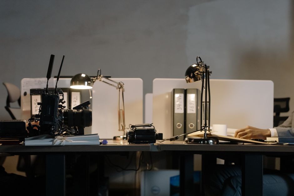 Configuración de oficina contemporánea con escritorios, lámparas y espacio de trabajo dividido
